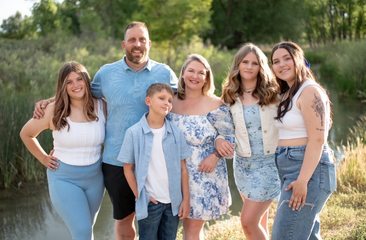 Family portrait by a serene pond in nature