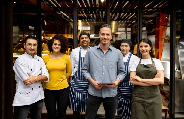Restaurant team posing outside with a tablet