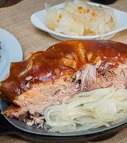 A variety of delicious dishes on plates, including sandwiches, pastries, and drinks, presented on a wooden table.