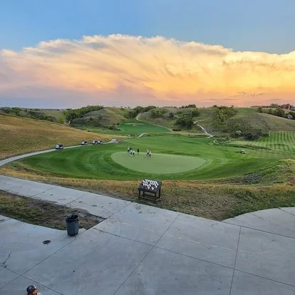 Scenic golf course at sunset with rolling hills