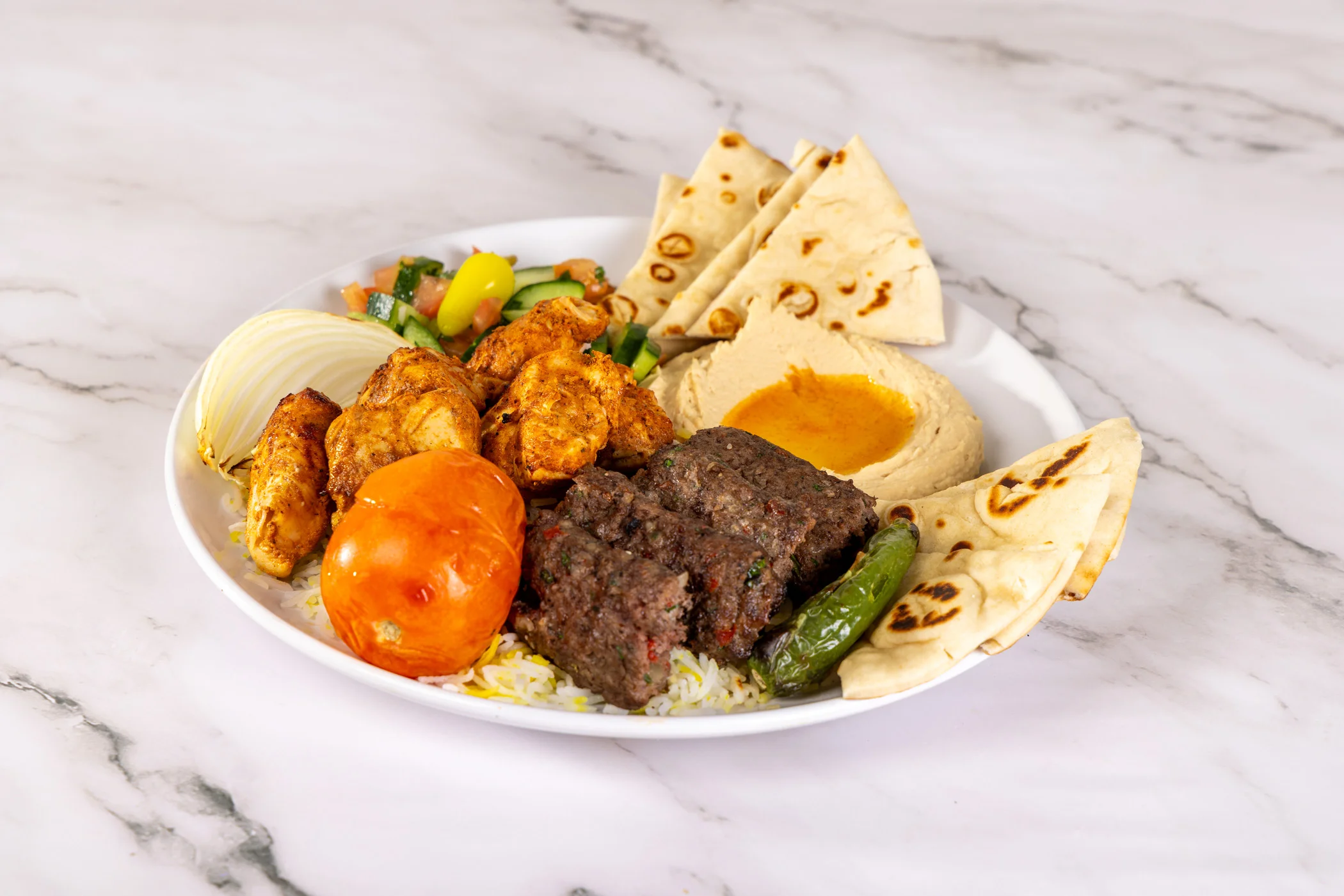Delicious shawarma plate with meat, vegetables, and sauces.