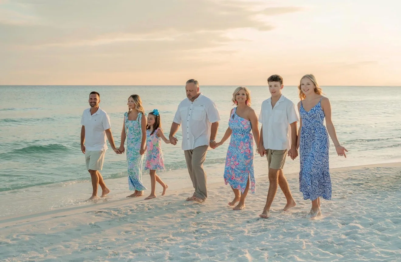 Family walking on the beach at sunset