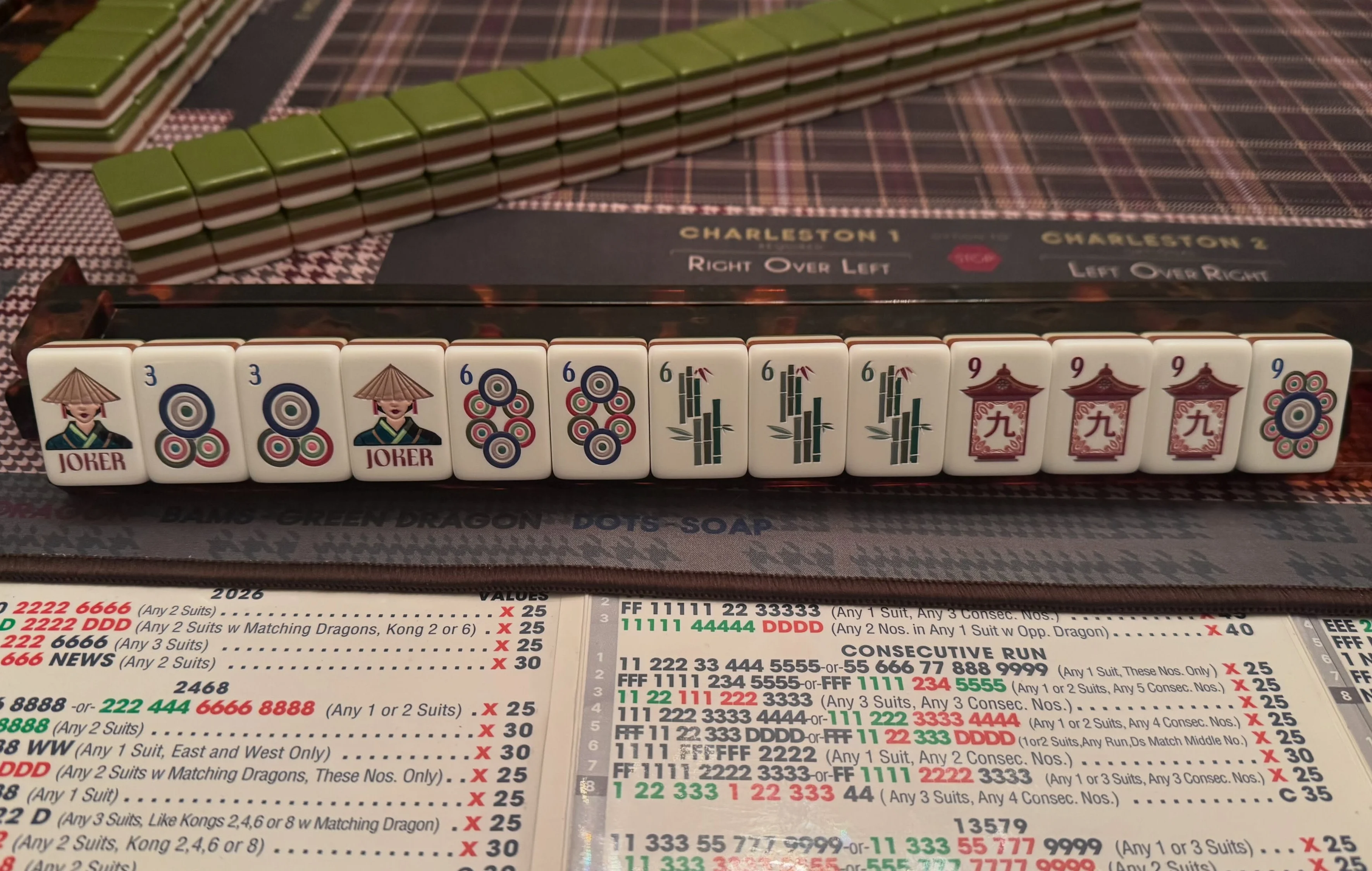 Mahjong game setup with tiles and scoring sheets on a table