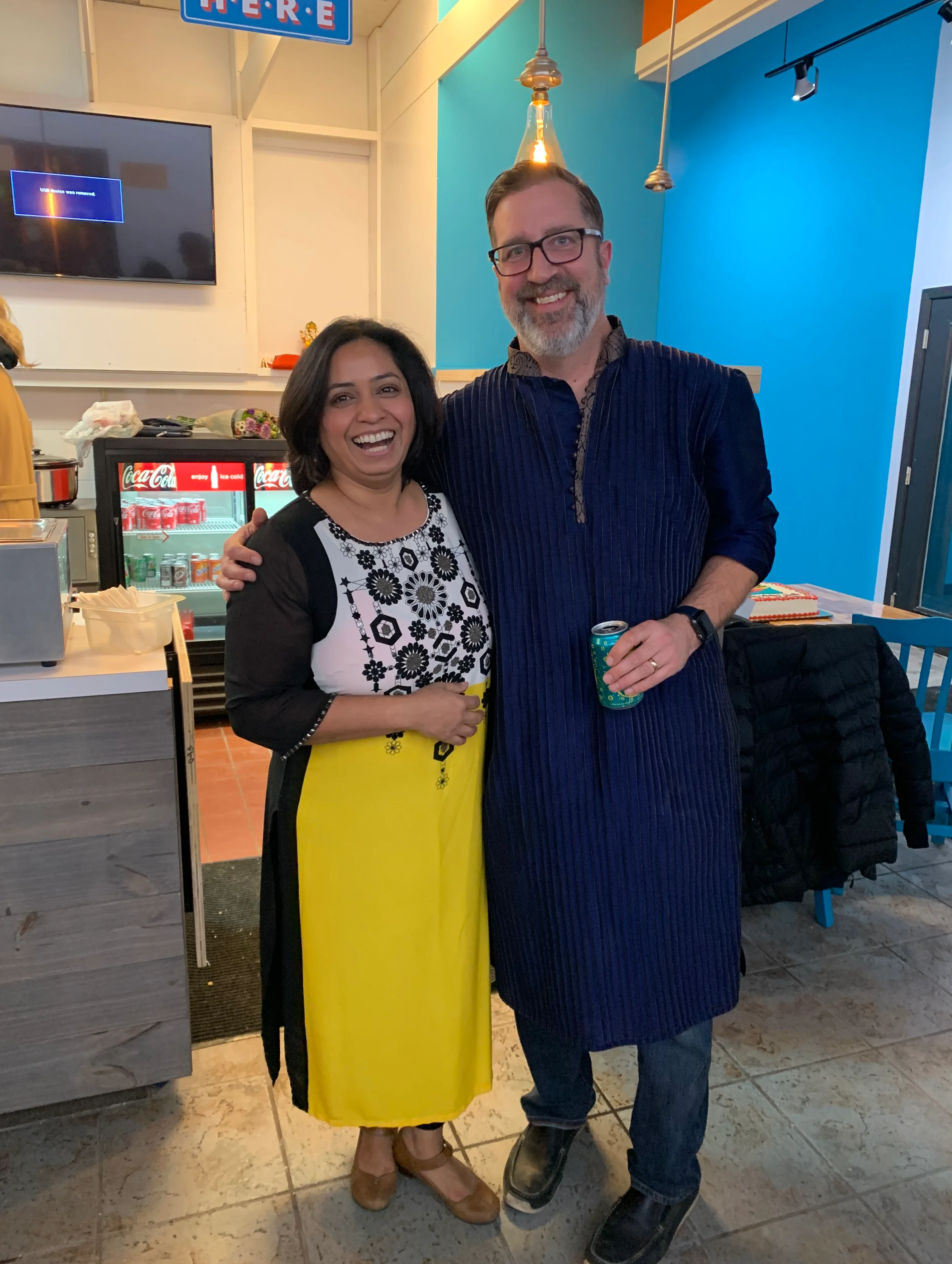 Two smiling individuals in a vibrant restaurant setting