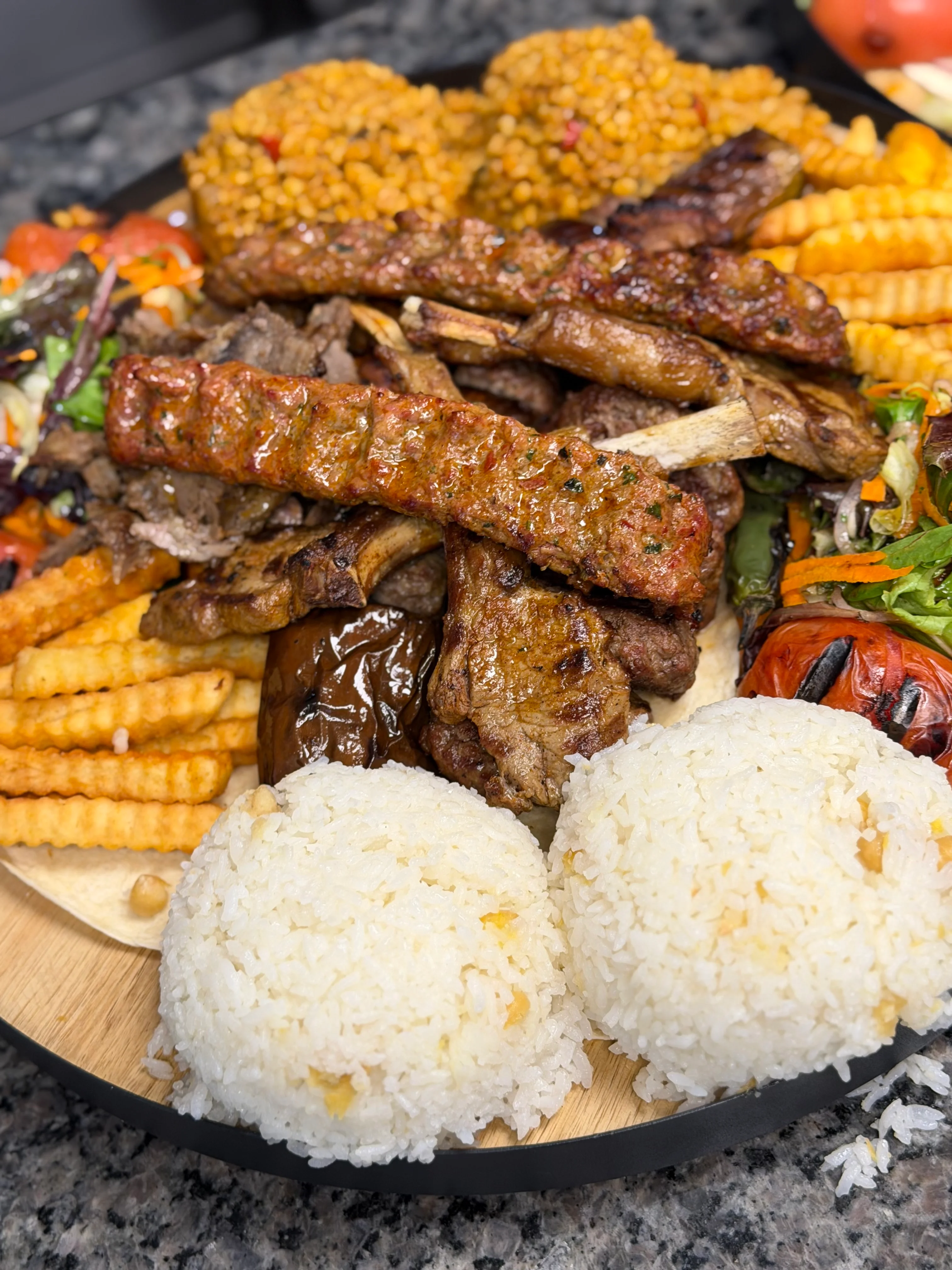Mixed grill platter featuring kebabs and rice