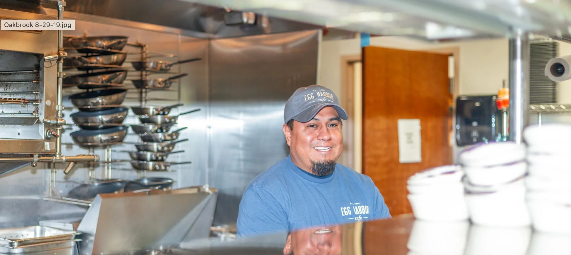Chef smiling in a bustling restaurant kitchen