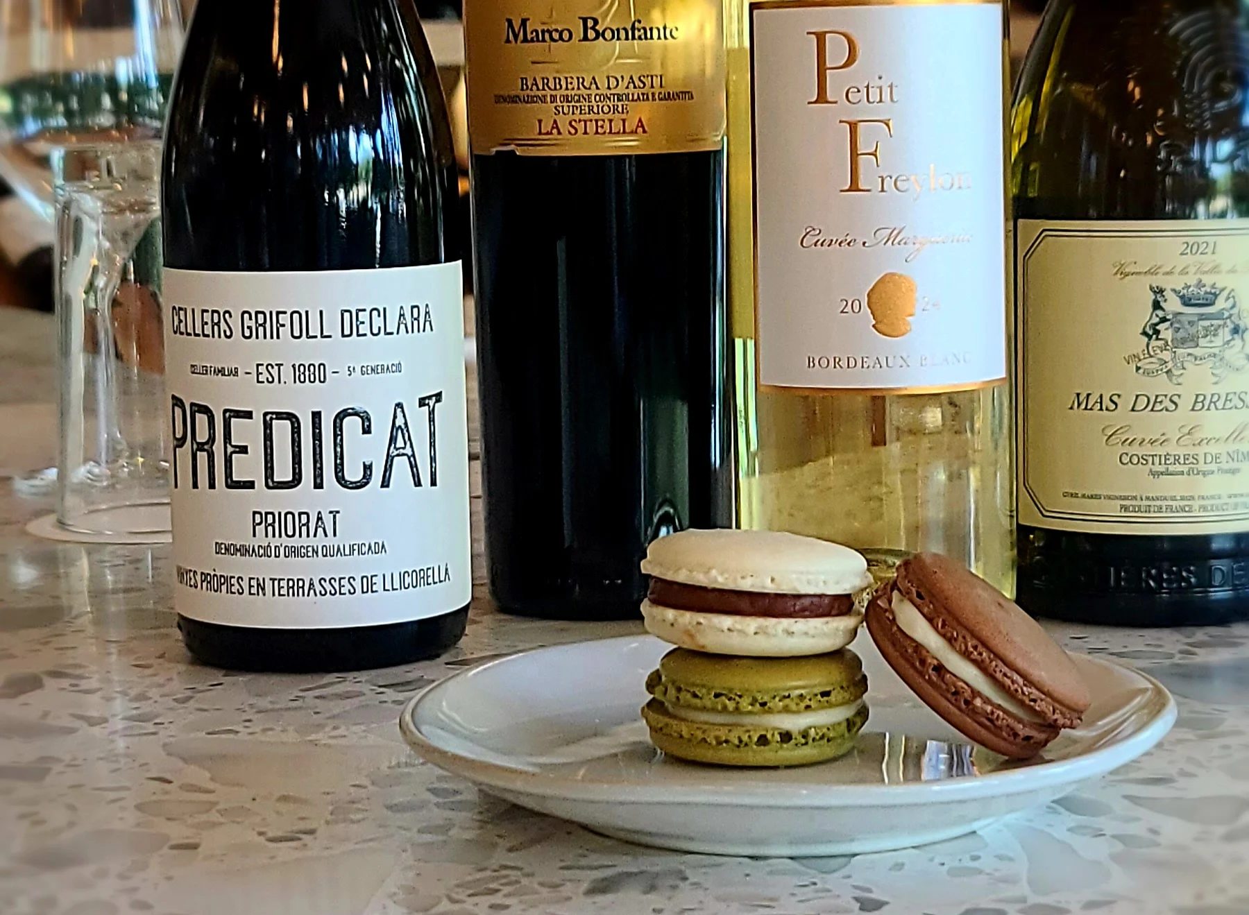 Selection of fine wines with macarons on a marble table