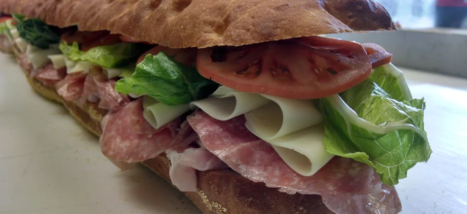 Italian sub sandwich loaded with meats and fresh vegetables