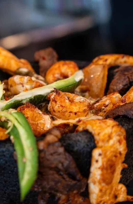 Sizzling Mexican fajitas served in a traditional stone bowl