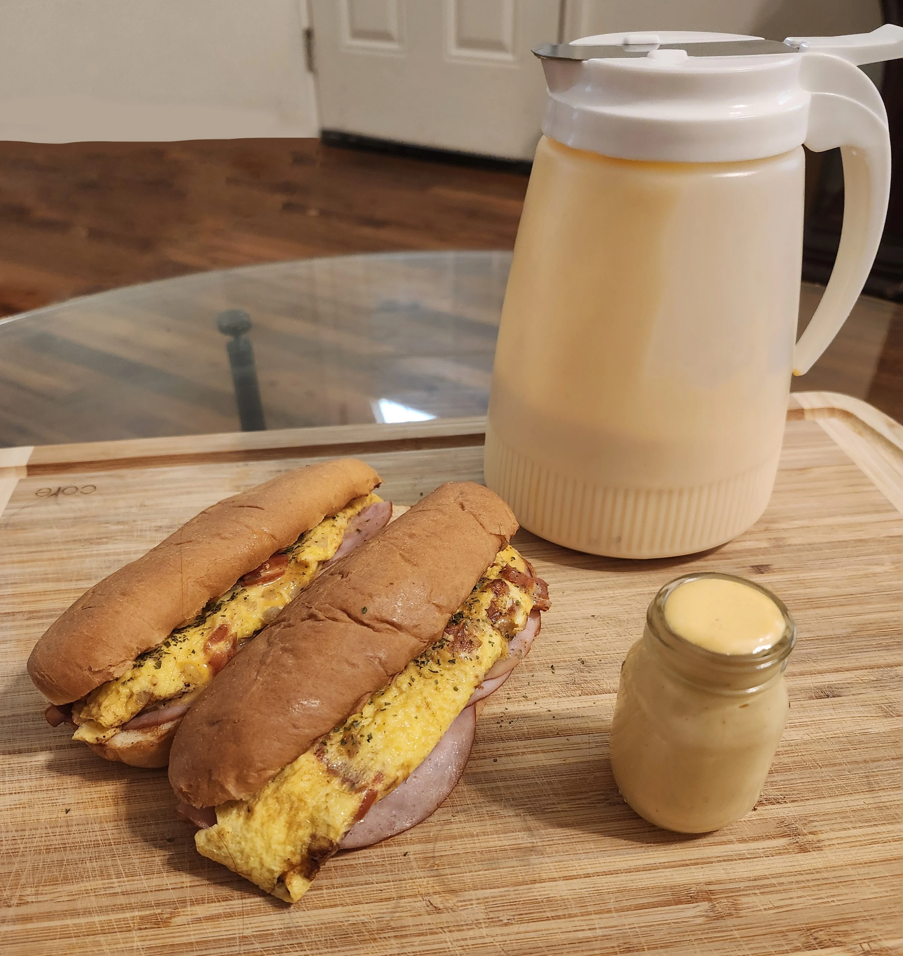 Breakfast sandwich with omelette in a soft bun, served with sauce