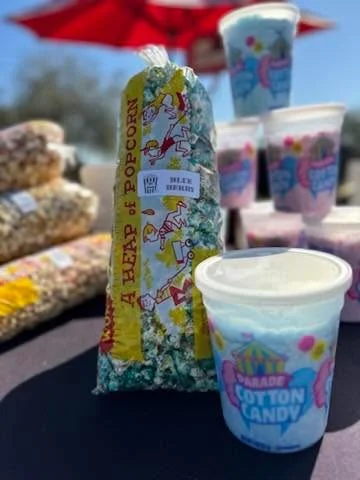 A vibrant assortment of popcorn labeled 'CARAMEL APPLE' in a similarly styled box. The background features green and yellow popcorn kernels.