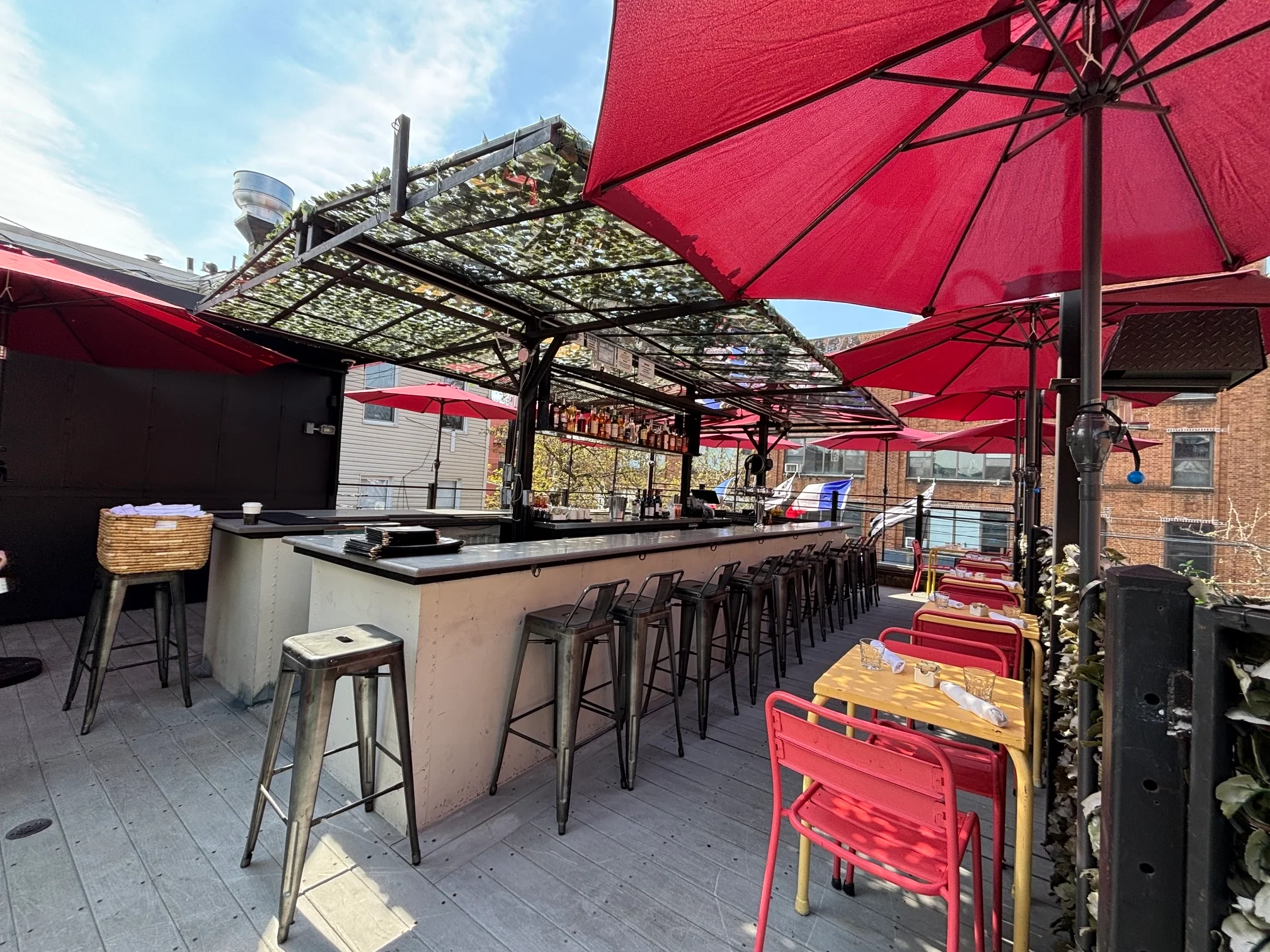 Stylish outdoor bar with red umbrellas and modern seating