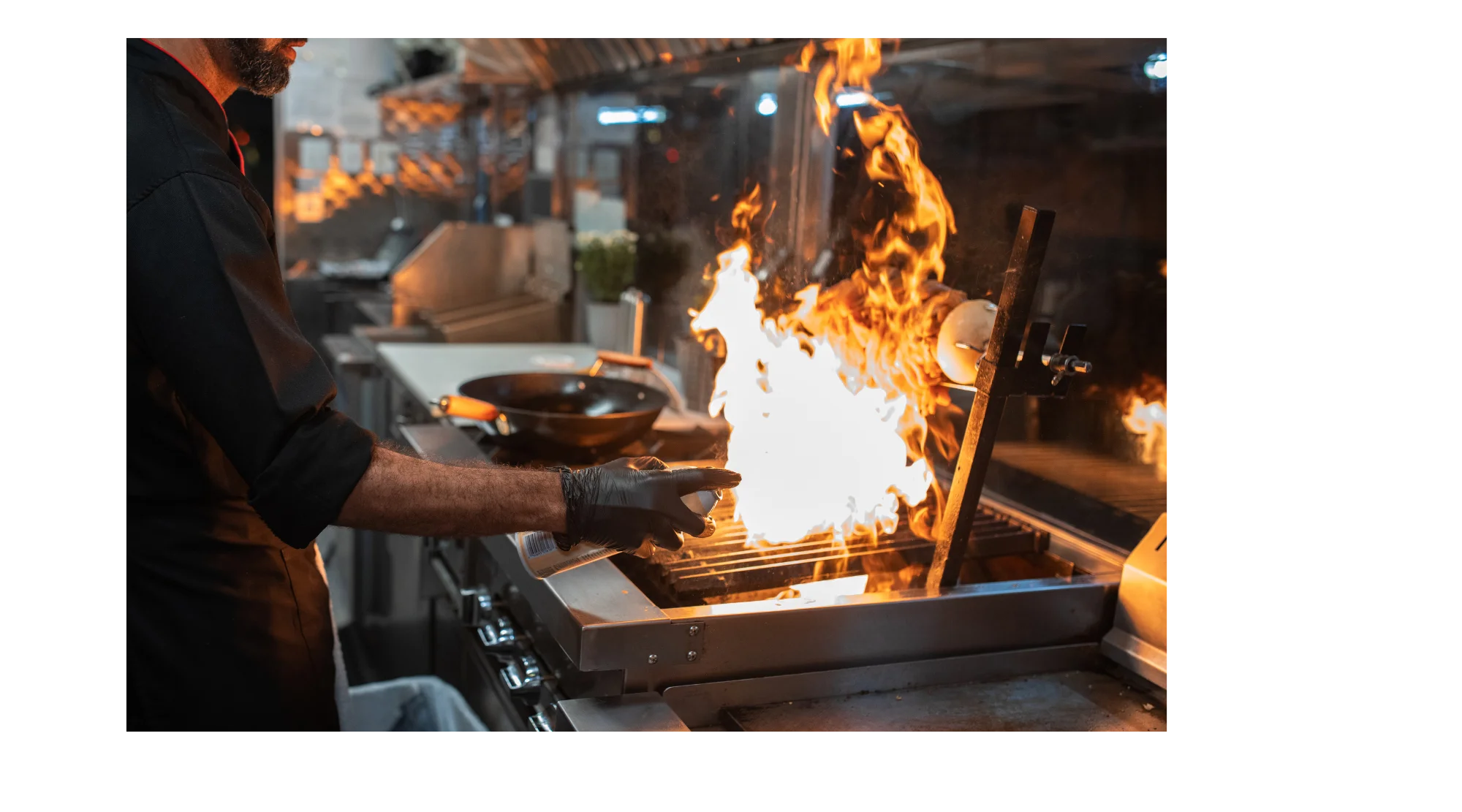 Chef grilling with flames in a professional kitchen