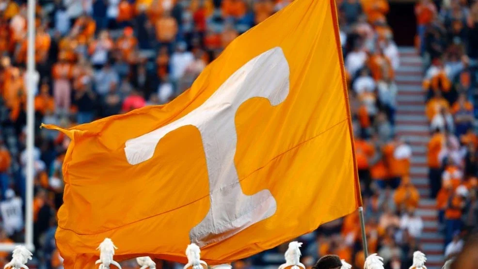 Tennessee flag waving at a sports event with an orange crowd.