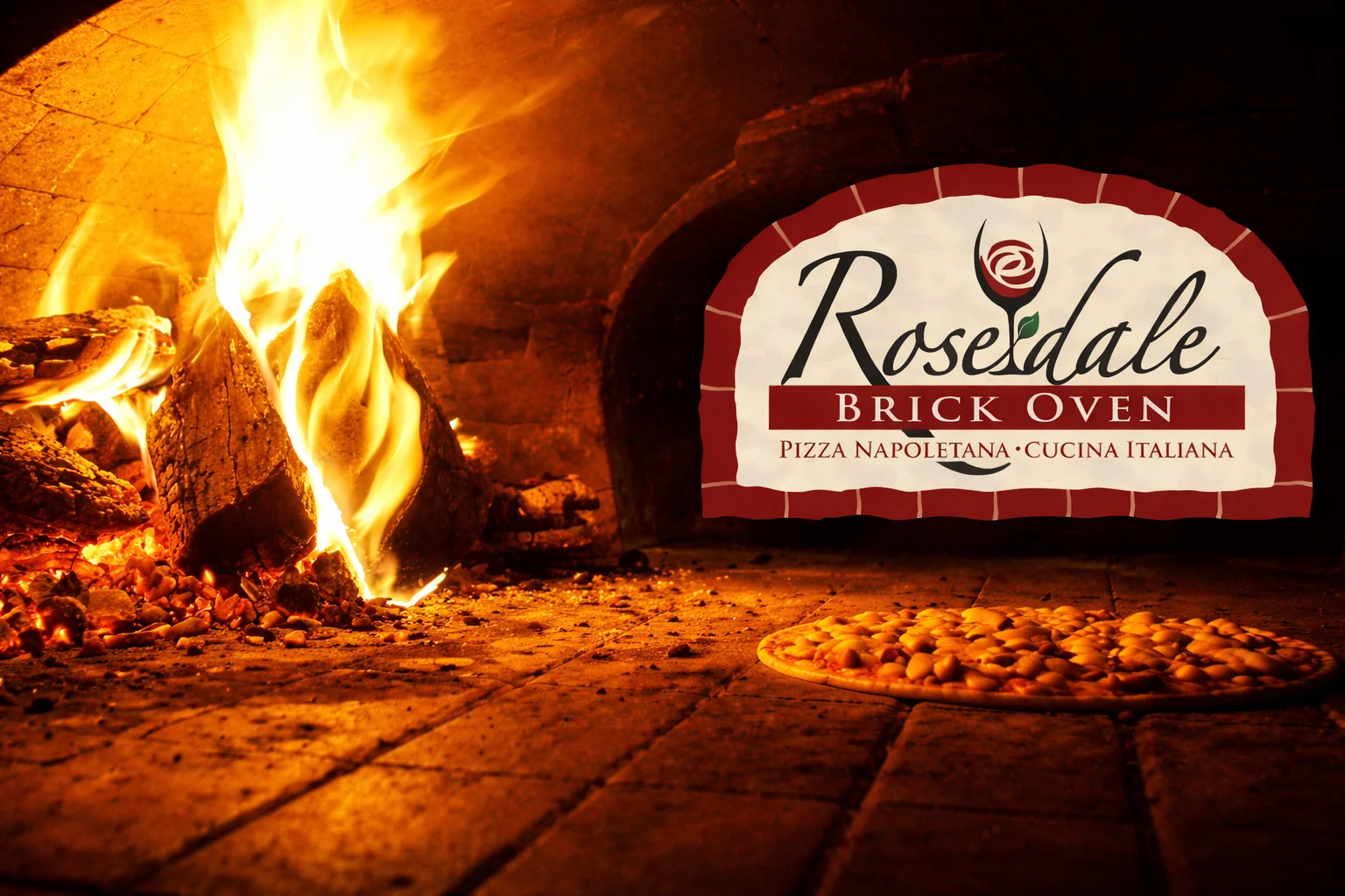 A wood-fired pizza oven with flames in the background. A freshly baked pizza with cheese and sauce is placed on a stone surface, alongside unbaked dough.