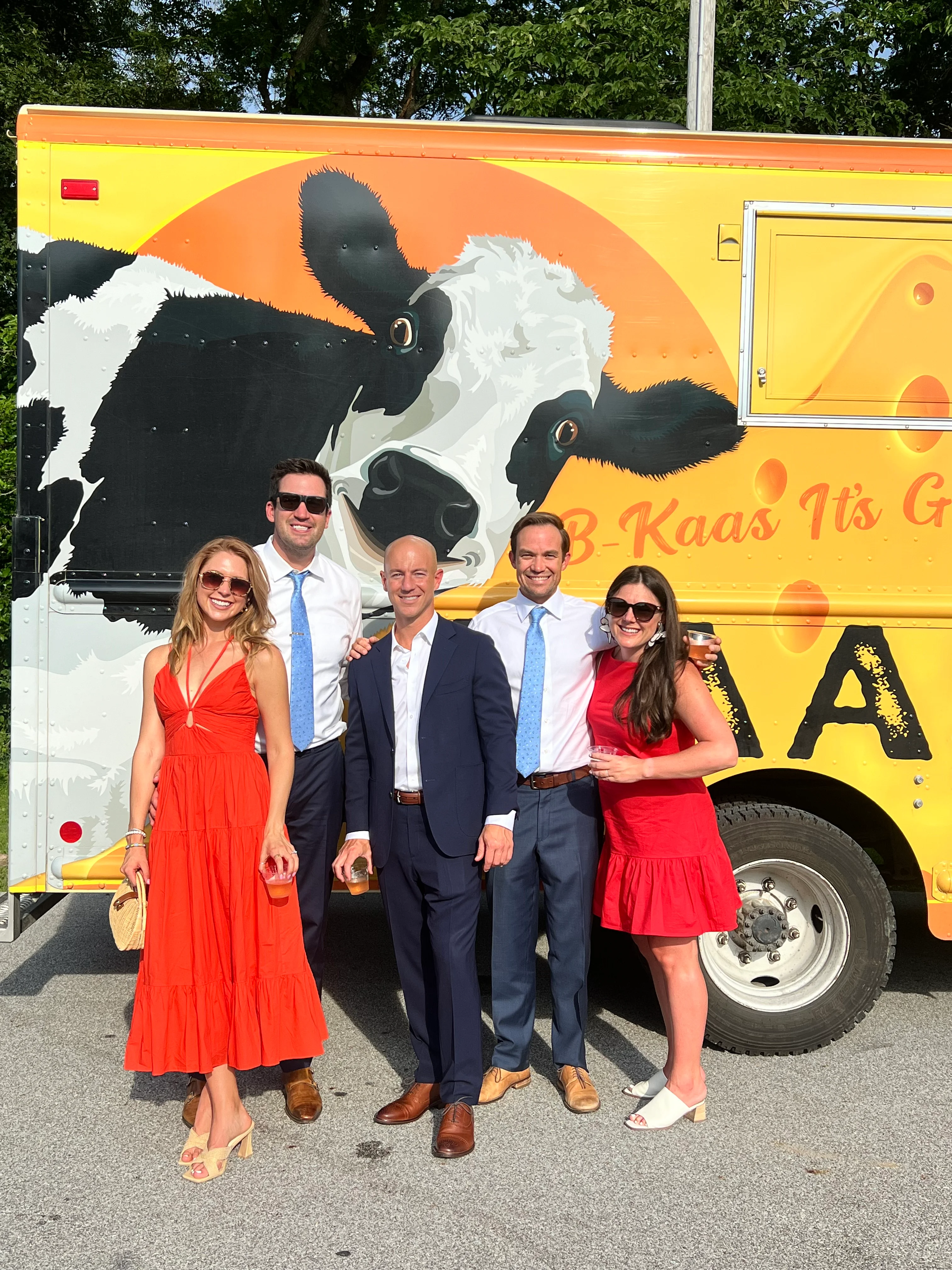 Group of friends posing by a colorful food truck
