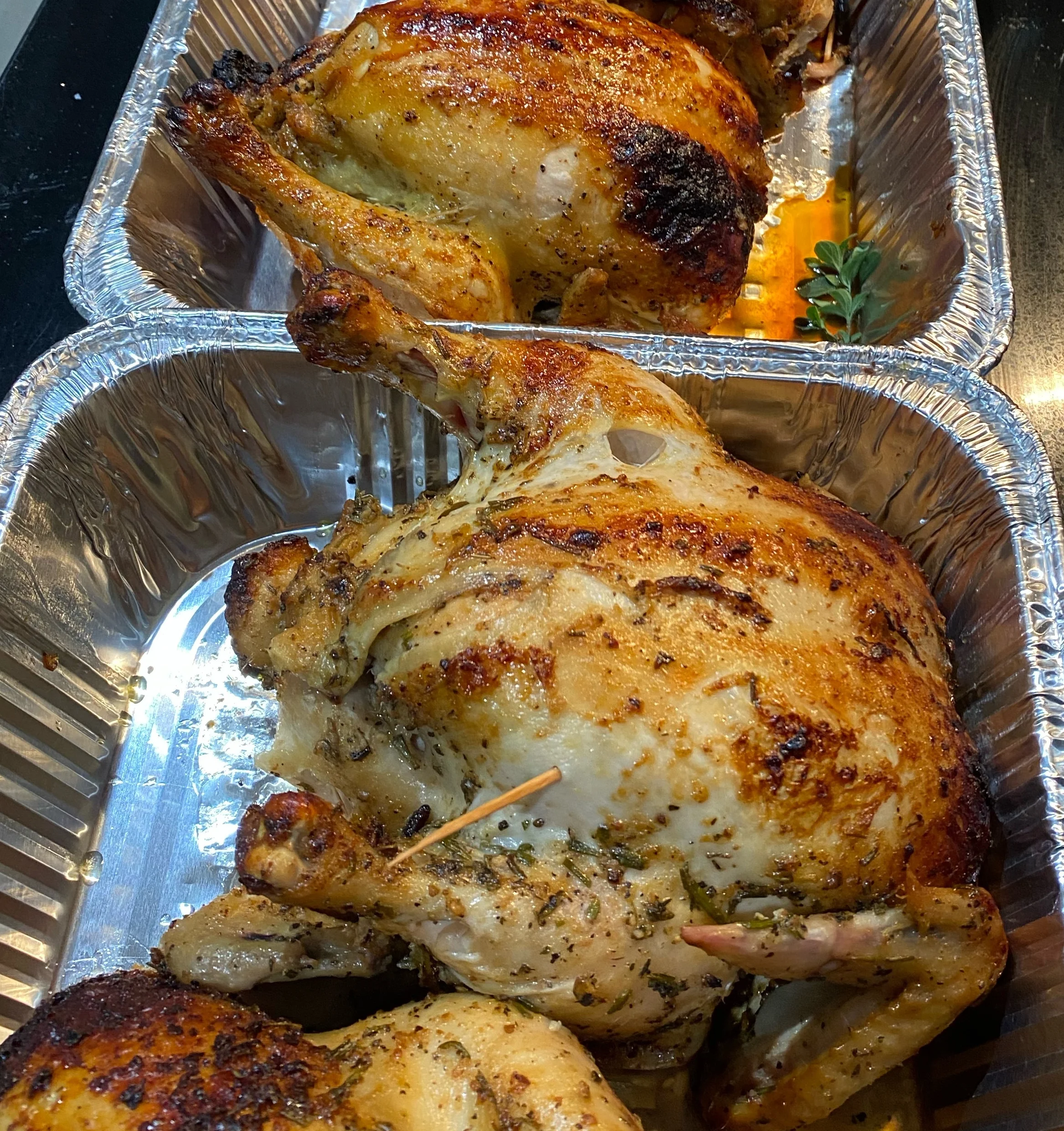 Roasted whole chickens in aluminum trays