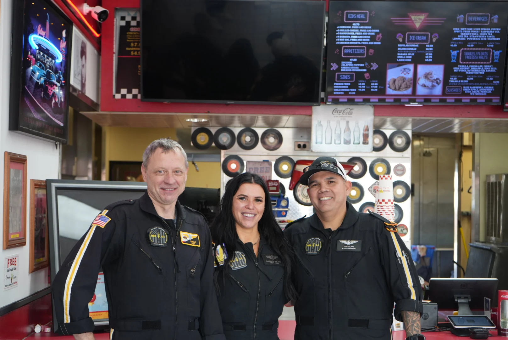 Friendly restaurant staff in flight suits at a retro-themed diner