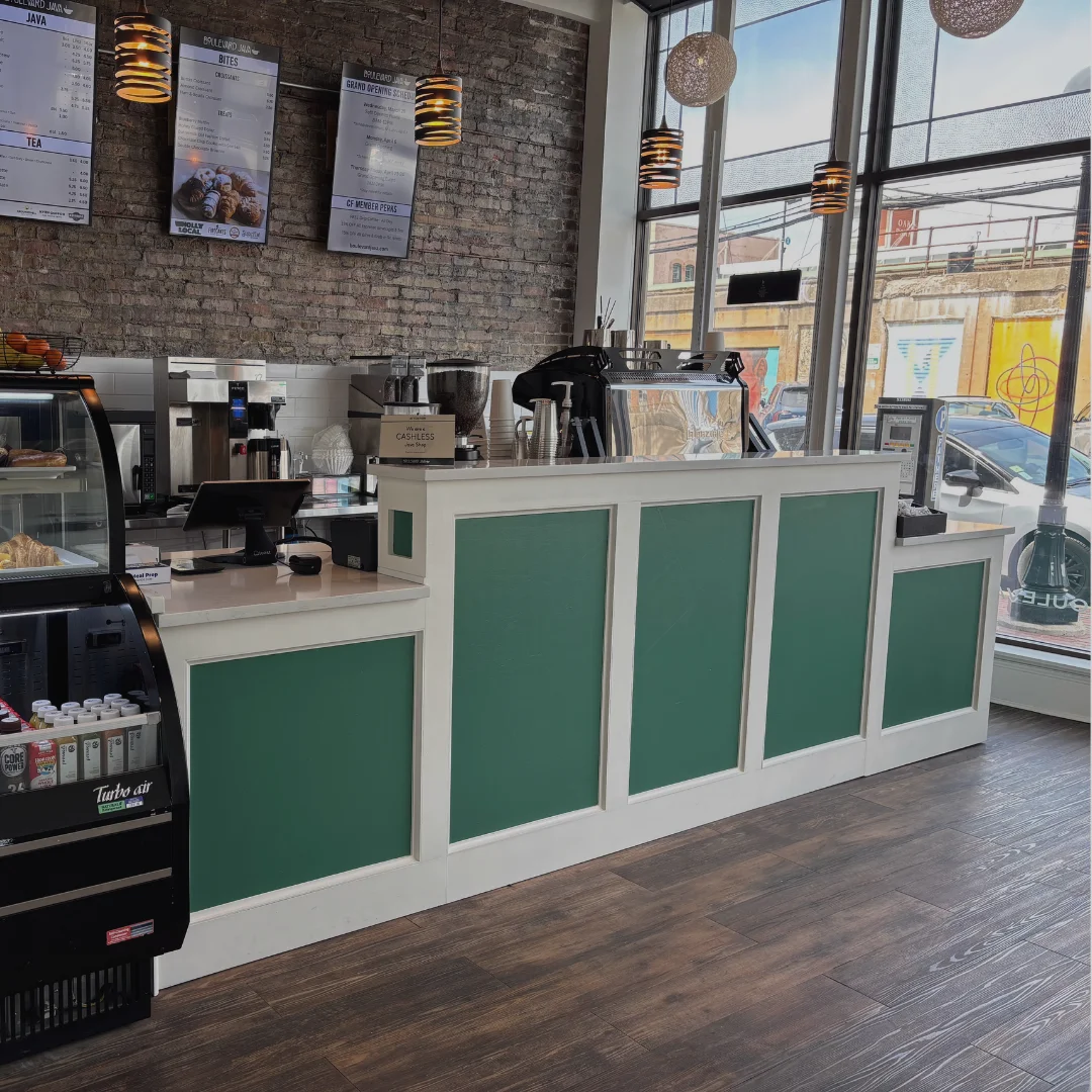 Modern café counter with green accents and menu boards