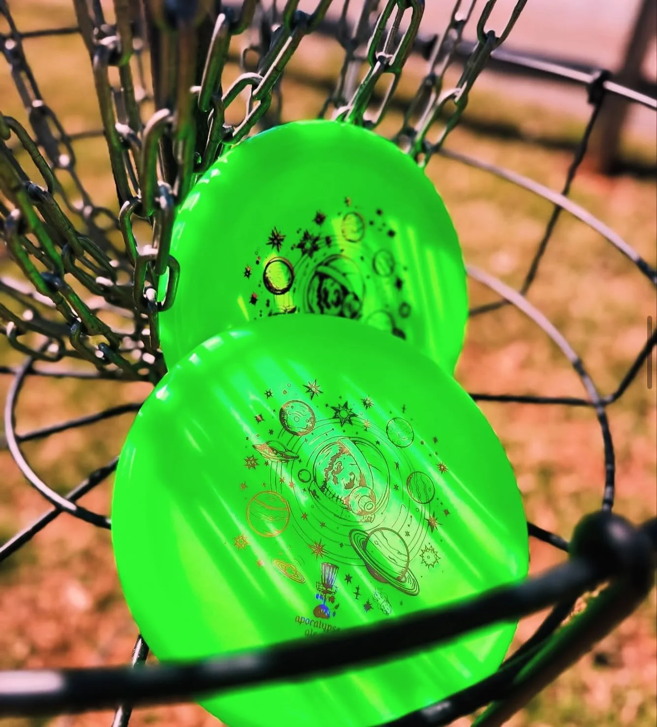 Two vibrant green disc golf discs in a basket