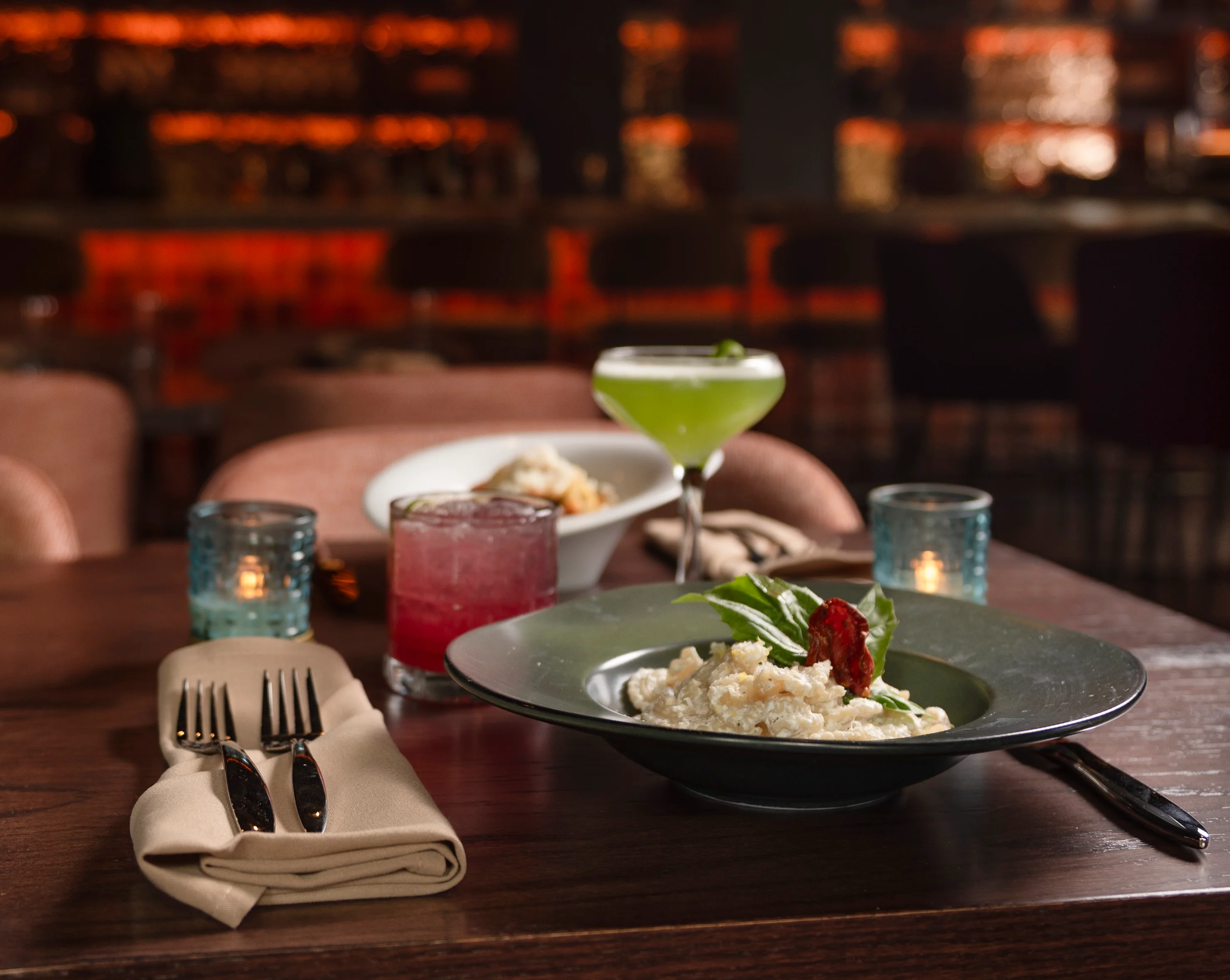 A picture of several drinks and a plate of food