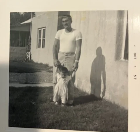 Black and white photo of a man and child outdoors in 1957