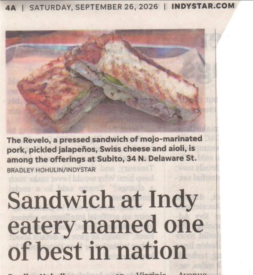 Pressed Cuban-style sandwich sliced on a newspaper page