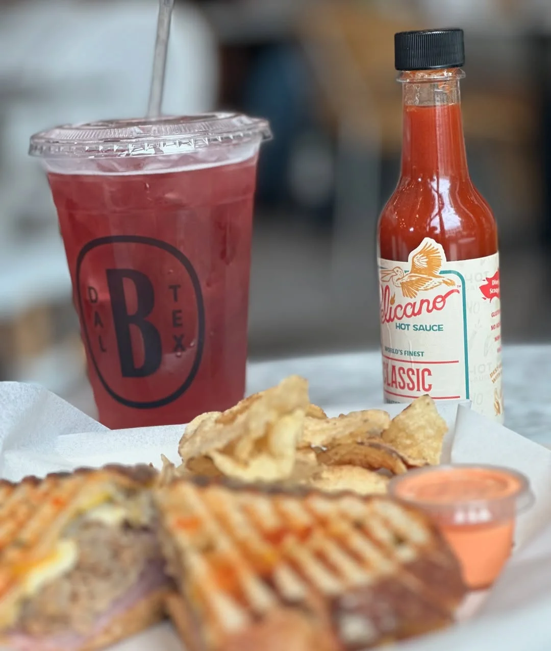 Grilled cheese sandwich with chips and a refreshing drink