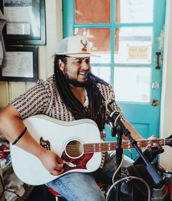 Musician performing live with acoustic guitar in a cozy restaurant setting