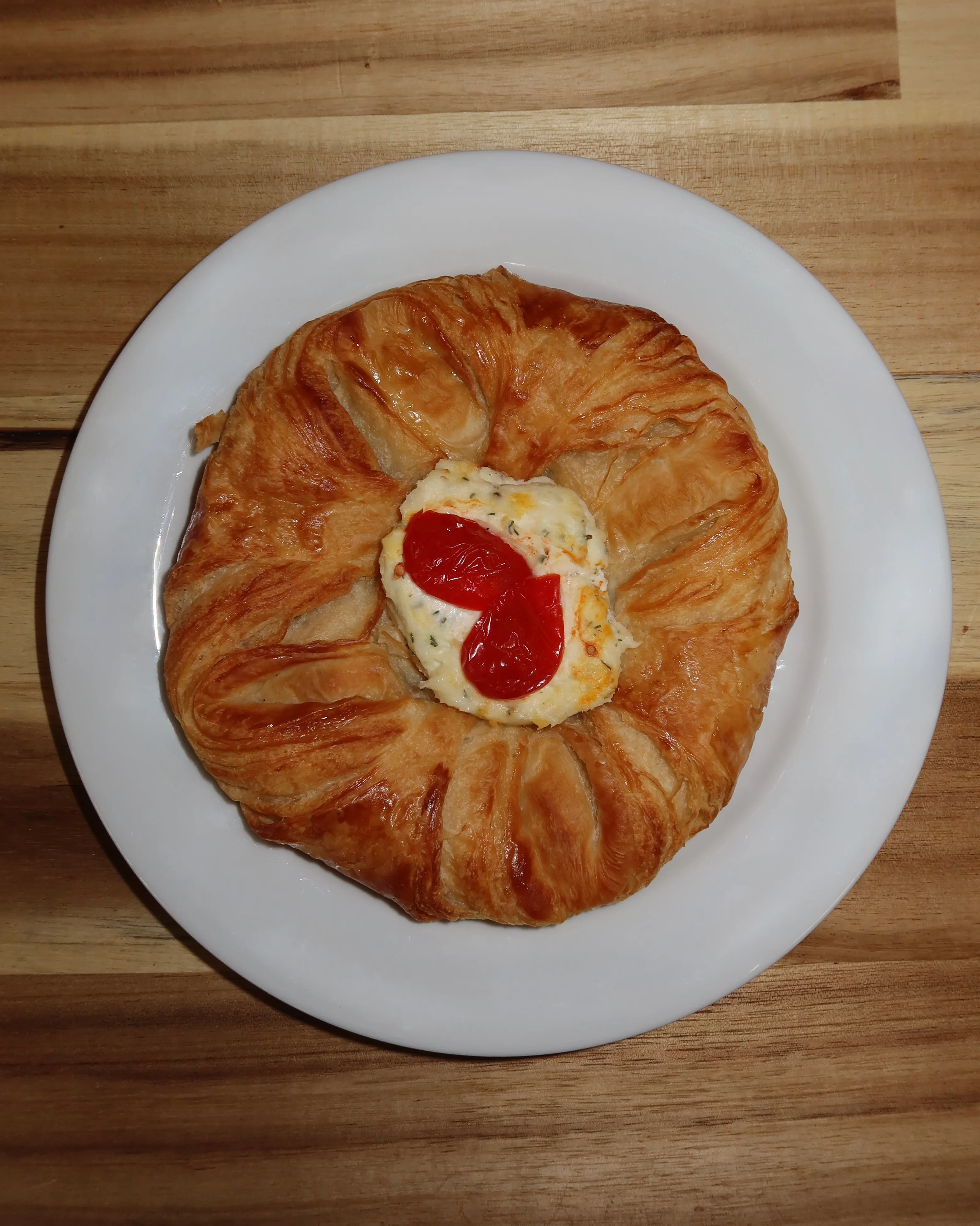 Savory French croissant with creamy filling and cherry tomatoes