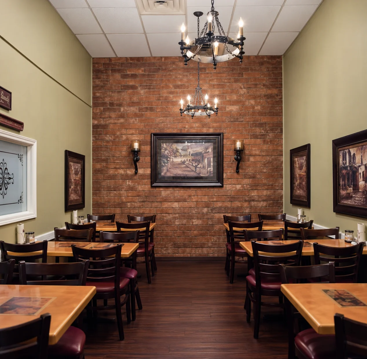 Warm restaurant dining room with exposed brick wall and chandeliers