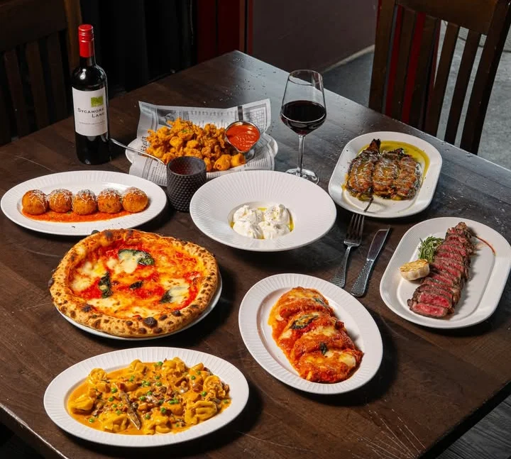 Italian feast featuring Margherita pizza and pasta dishes