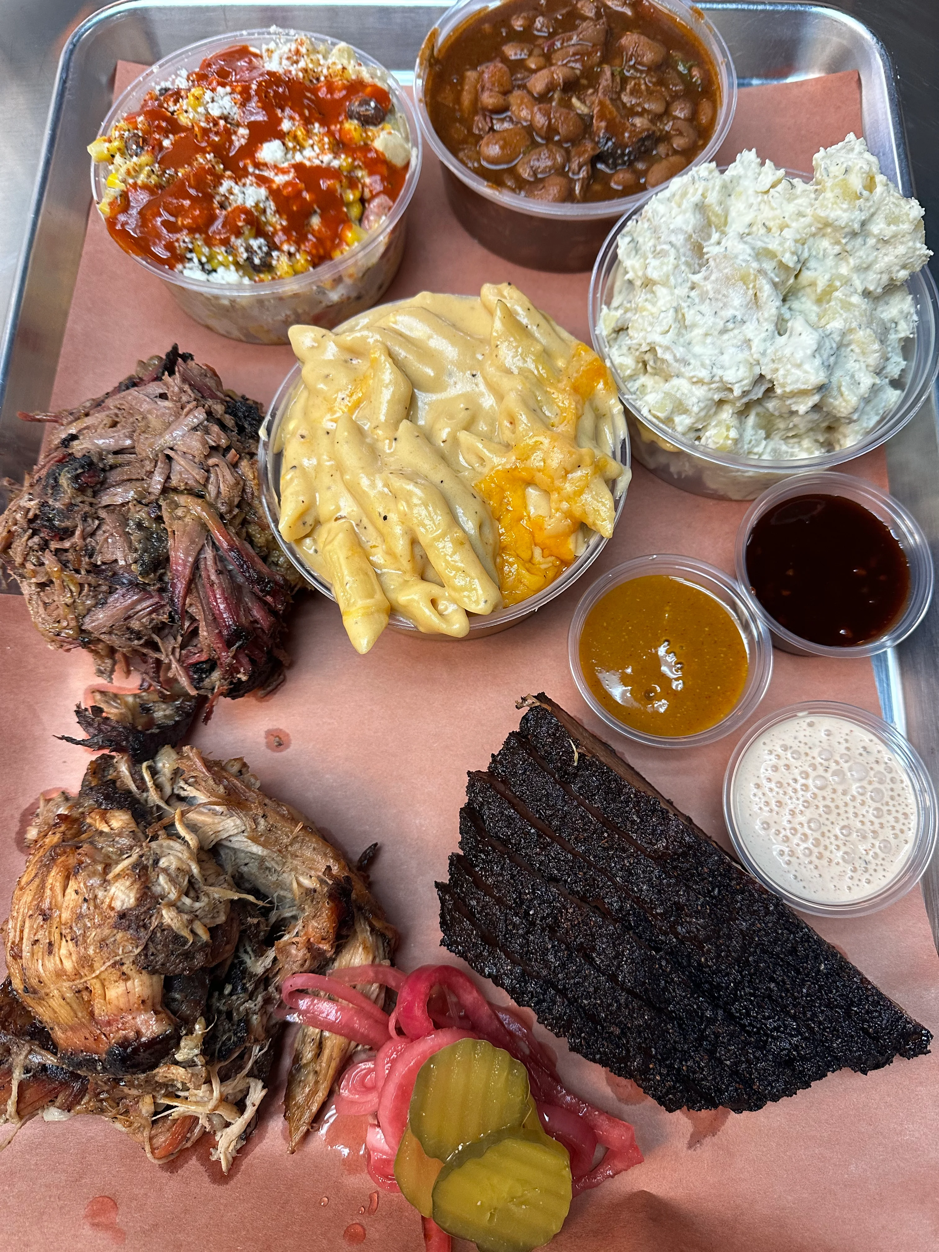 Assorted barbecue platter featuring smoked meats and sides