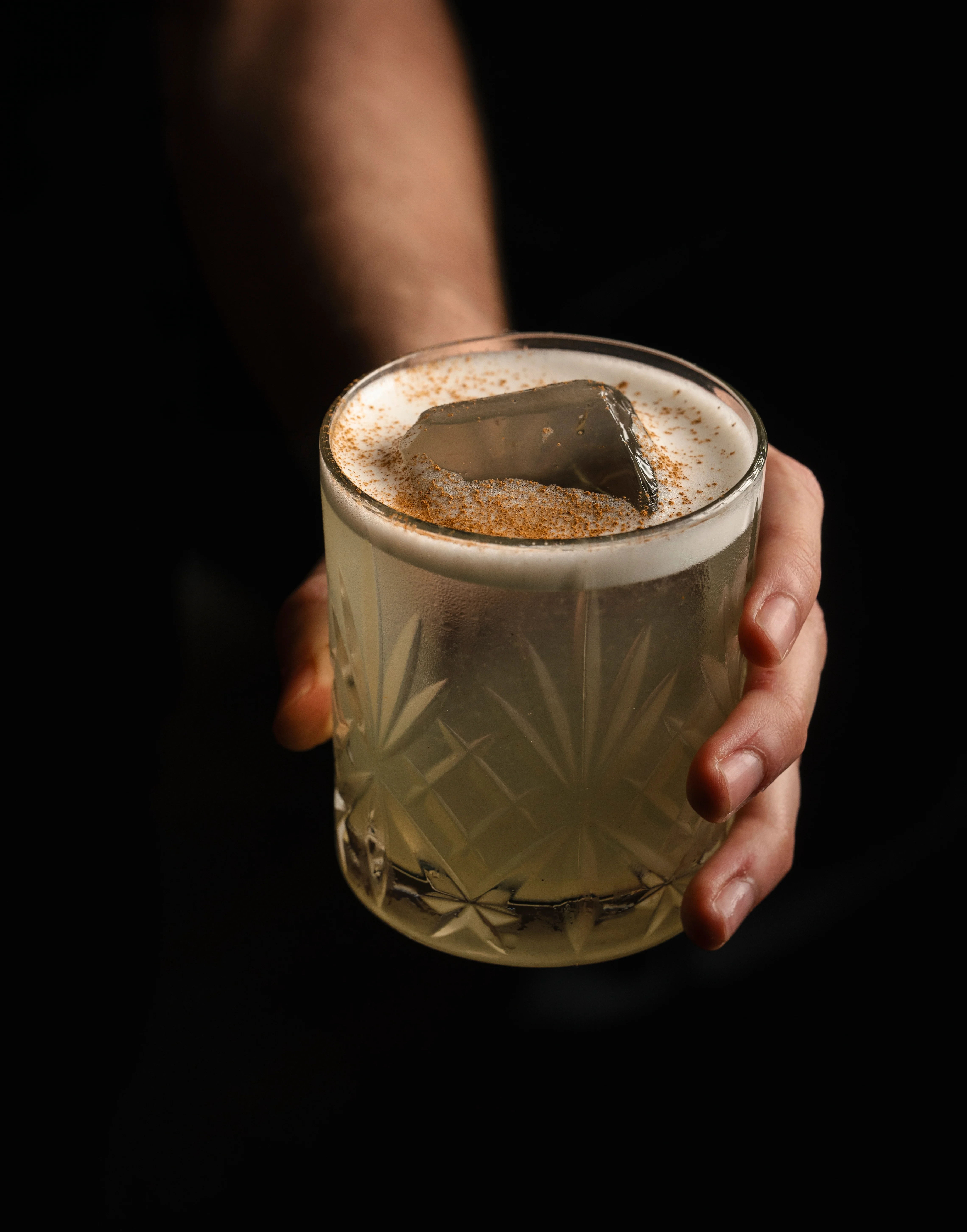 Bartender preparing a vibrant cocktail with a golden hue