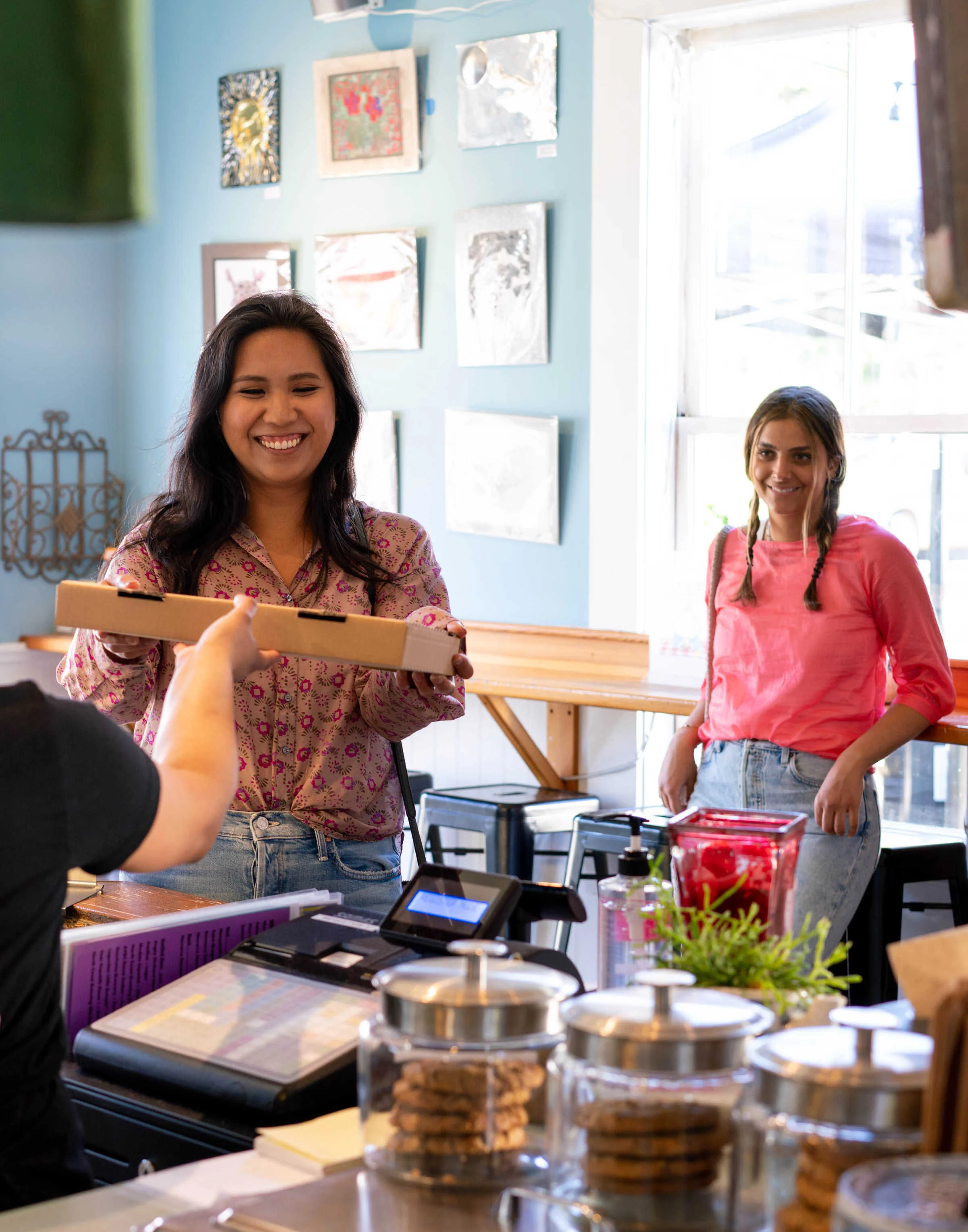 Woman and girl taking pizza to go from Frankie's Pizza & Ice Cream in Mendocino, California