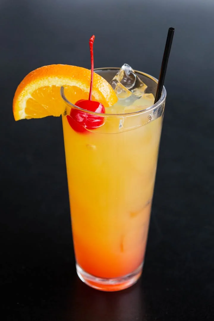 Colorful tropical cocktail with orange and cherry garnish