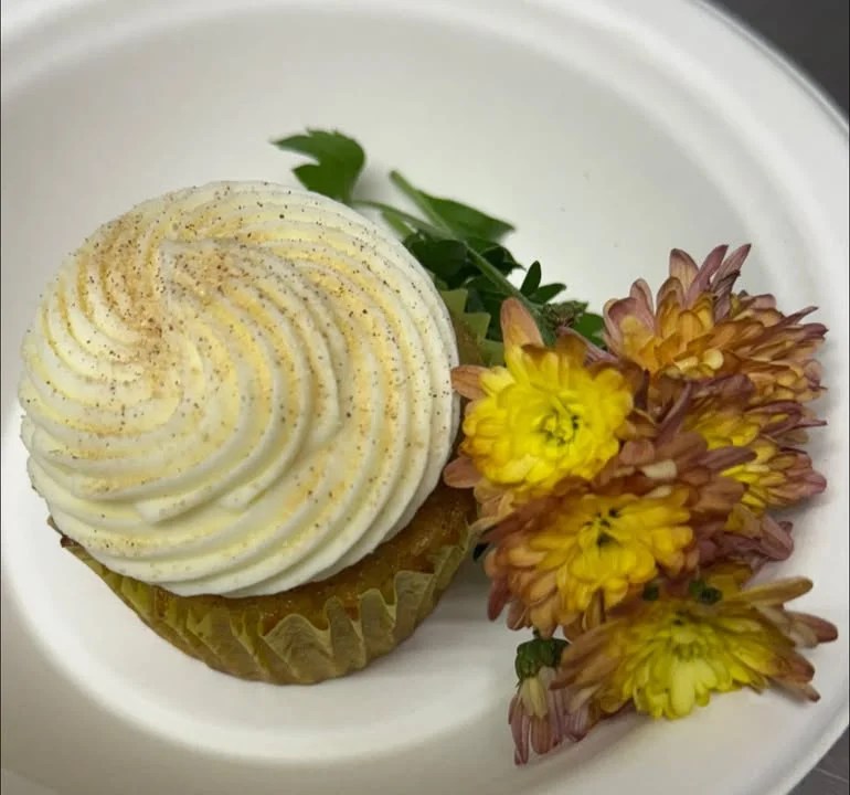 Delicious cupcake with swirled frosting and edible flowers