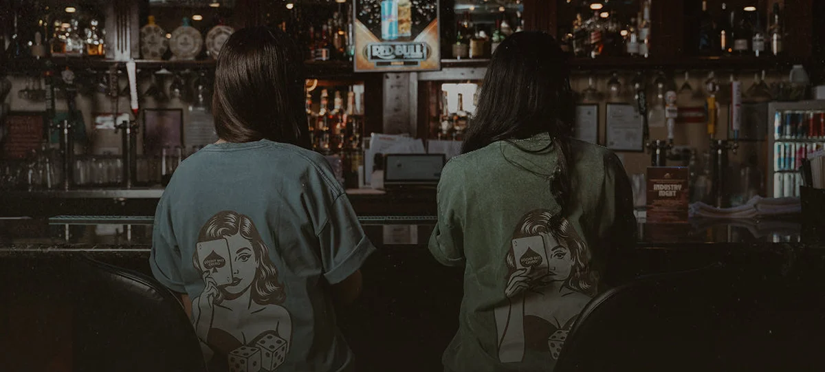 Two patrons seated at a dimly lit restaurant bar