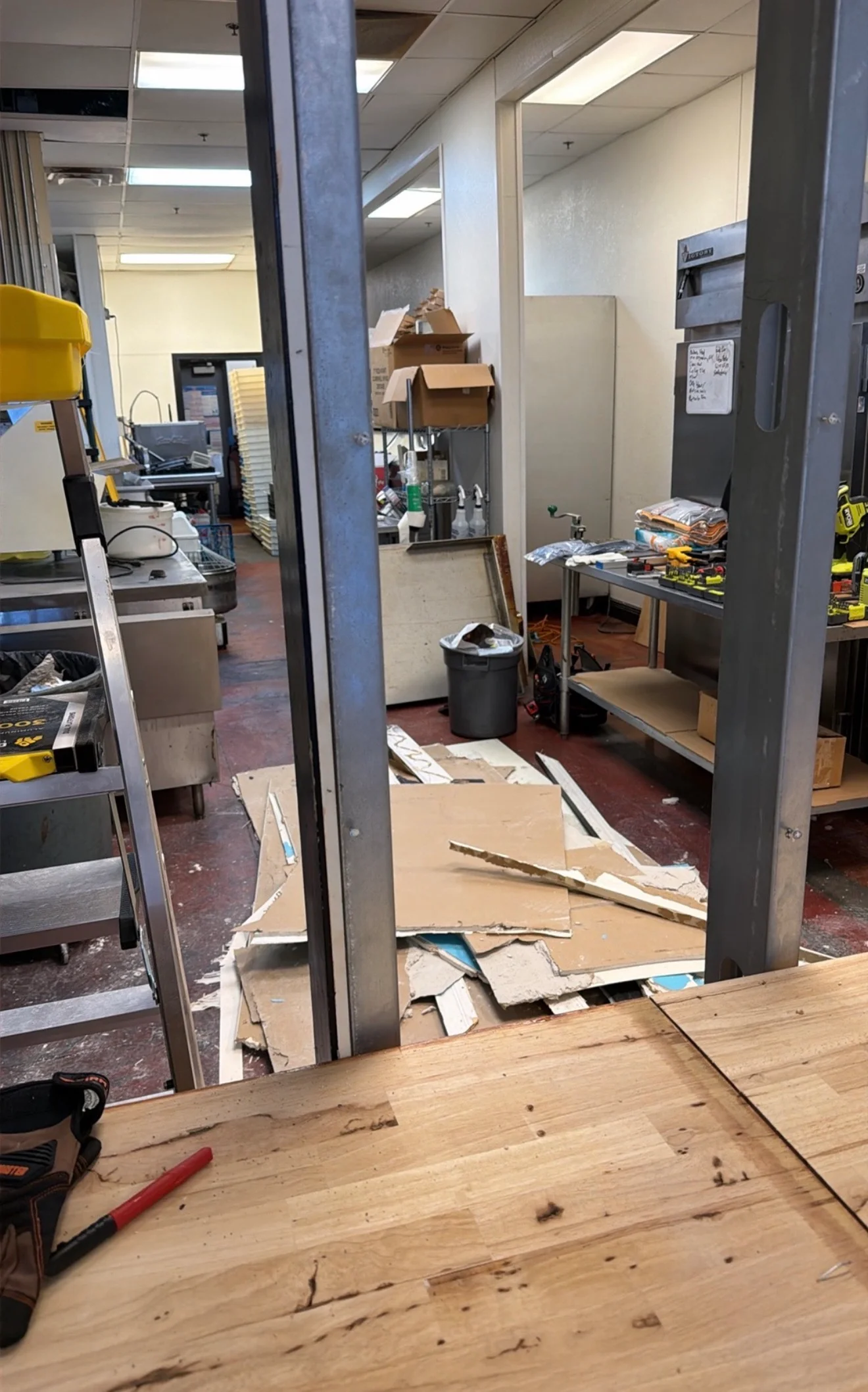 Restaurant kitchen under renovation with exposed equipment and construction debris