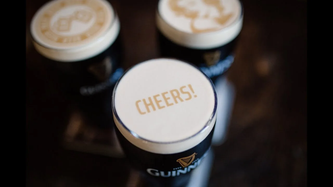 Pints of Guinness with 'Cheers!' on the foam