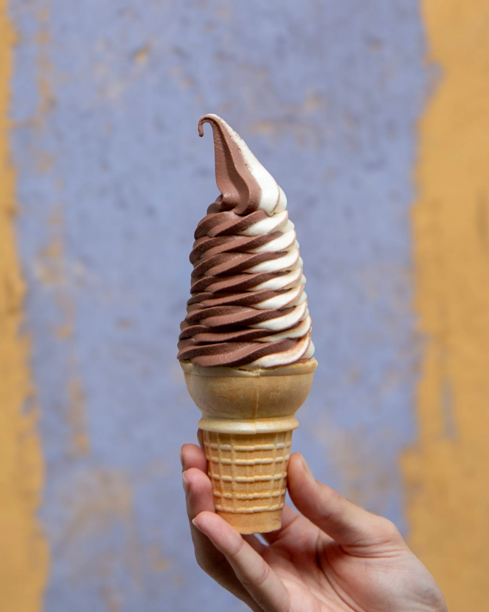 Swirled soft serve ice cream cone with chocolate and vanilla