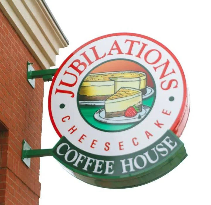 Signage for Jubilations Cheesecake Coffee House with cheesecake illustration