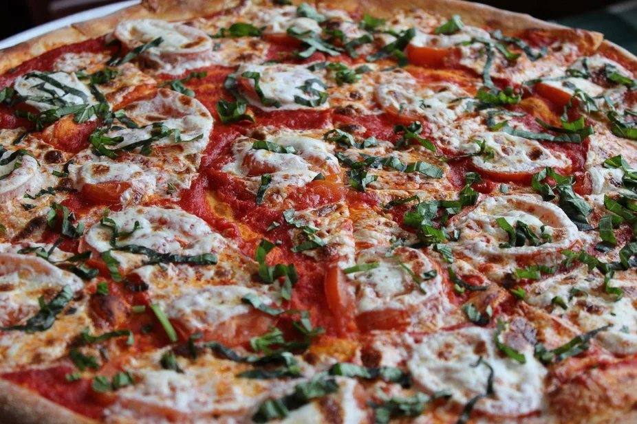 Margherita pizza topped with fresh basil and mozzarella