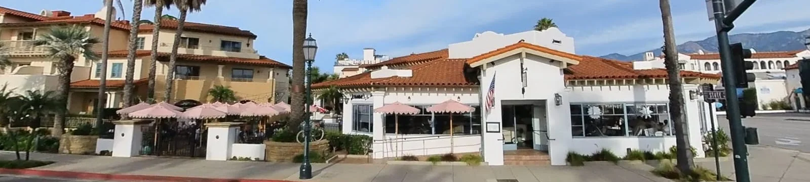 Charming restaurant exterior with palm trees and outdoor seating