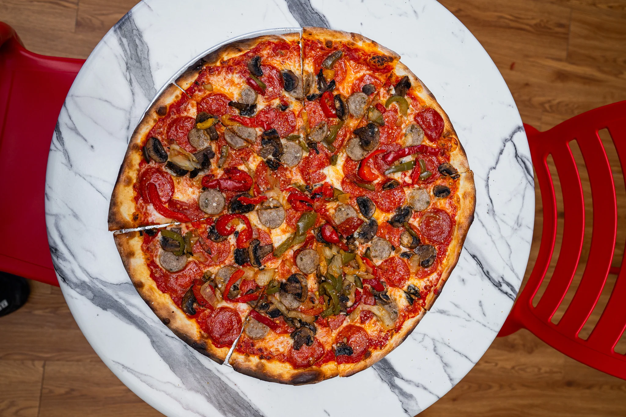 Loaded pepperoni pizza on a marble table