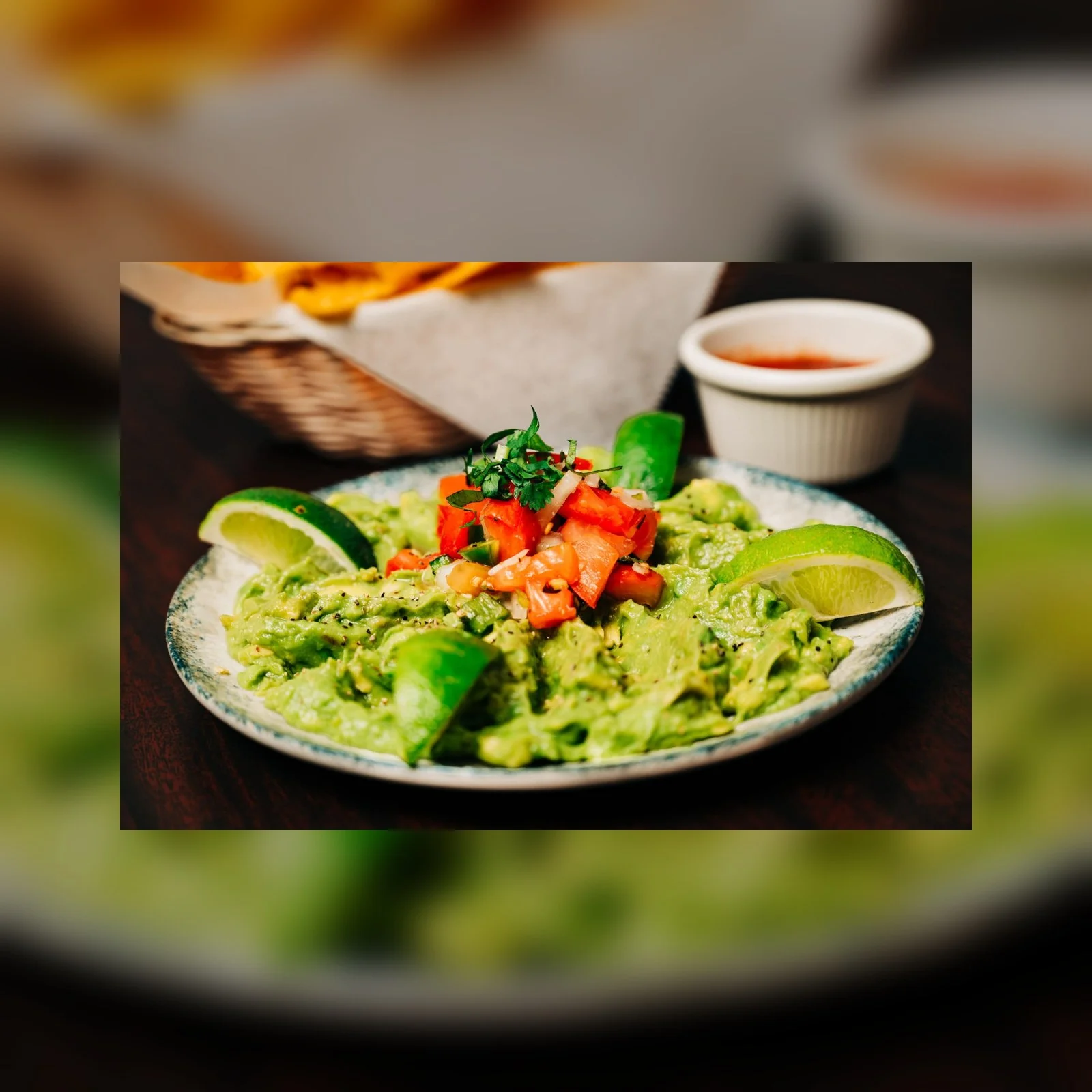 Fresh guacamole with tomatoes and lime wedges