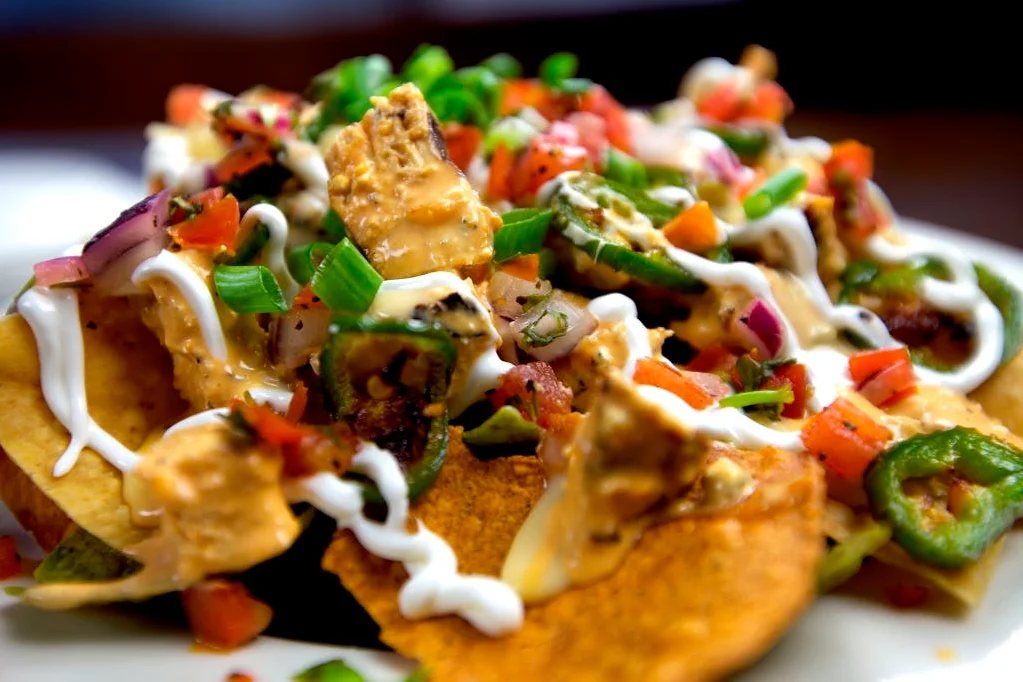 Loaded nachos topped with chicken and fresh vegetables