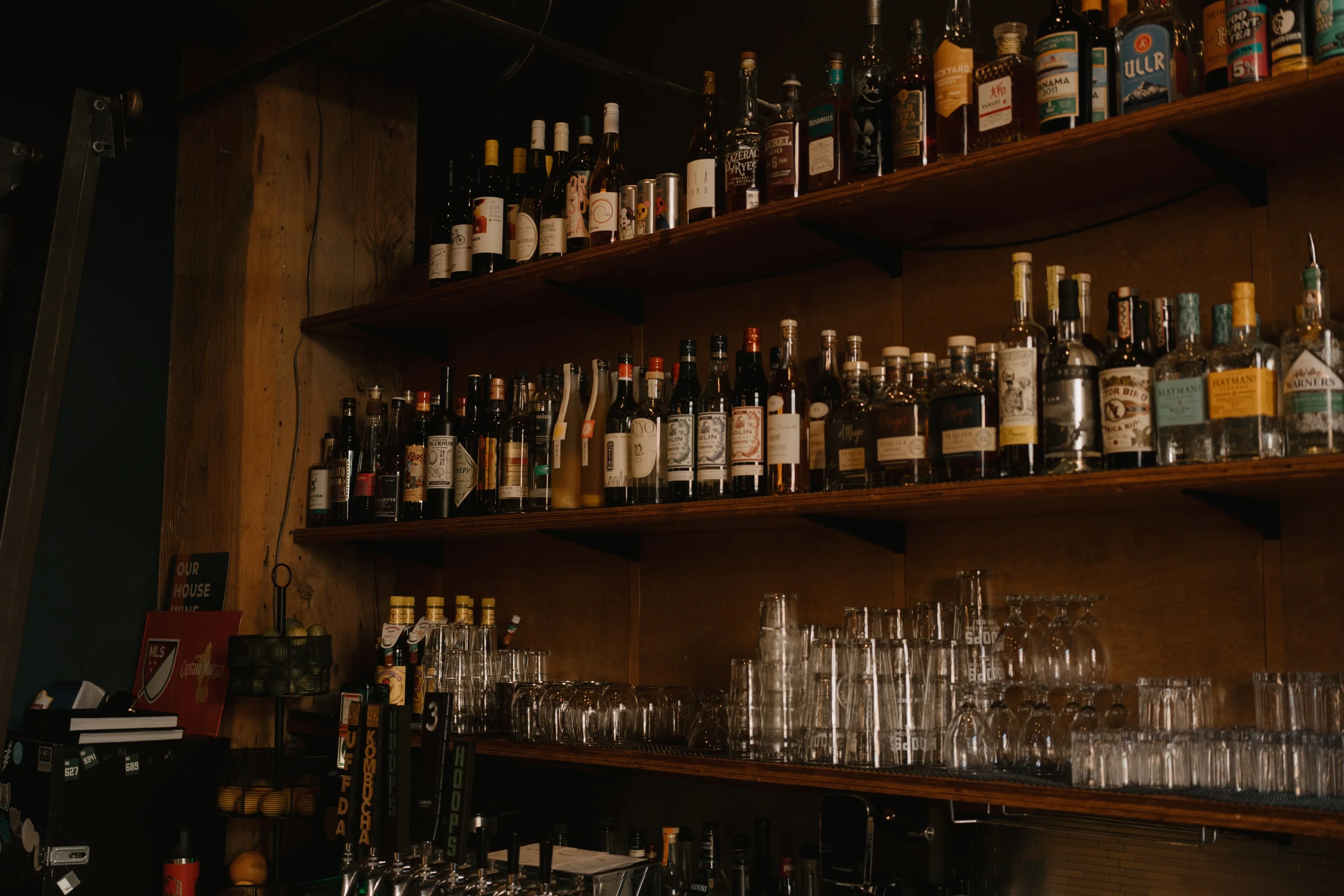 Well-stocked bar shelf with various spirits and glassware