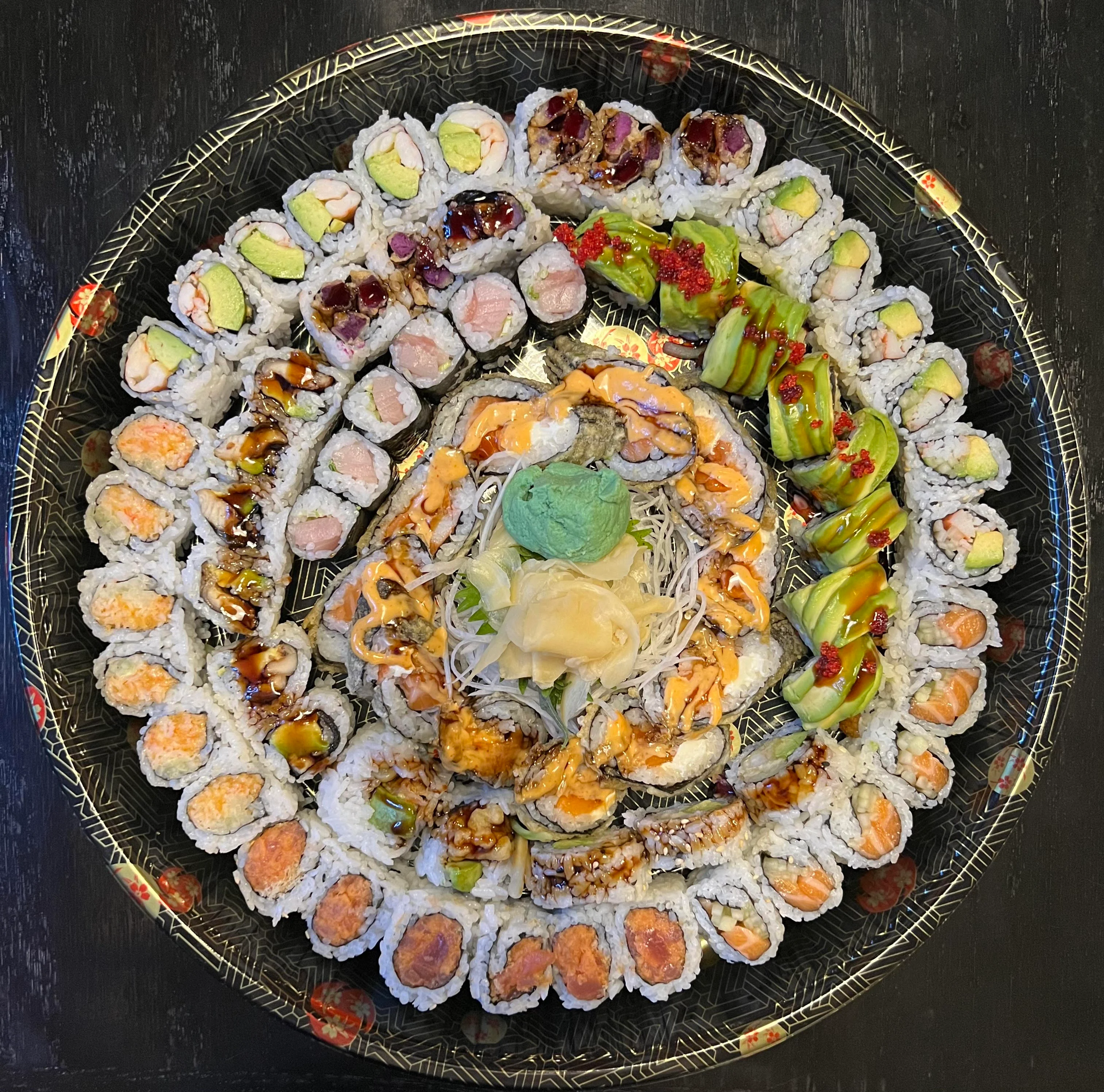 Assorted sushi platter featuring various rolls and garnishes