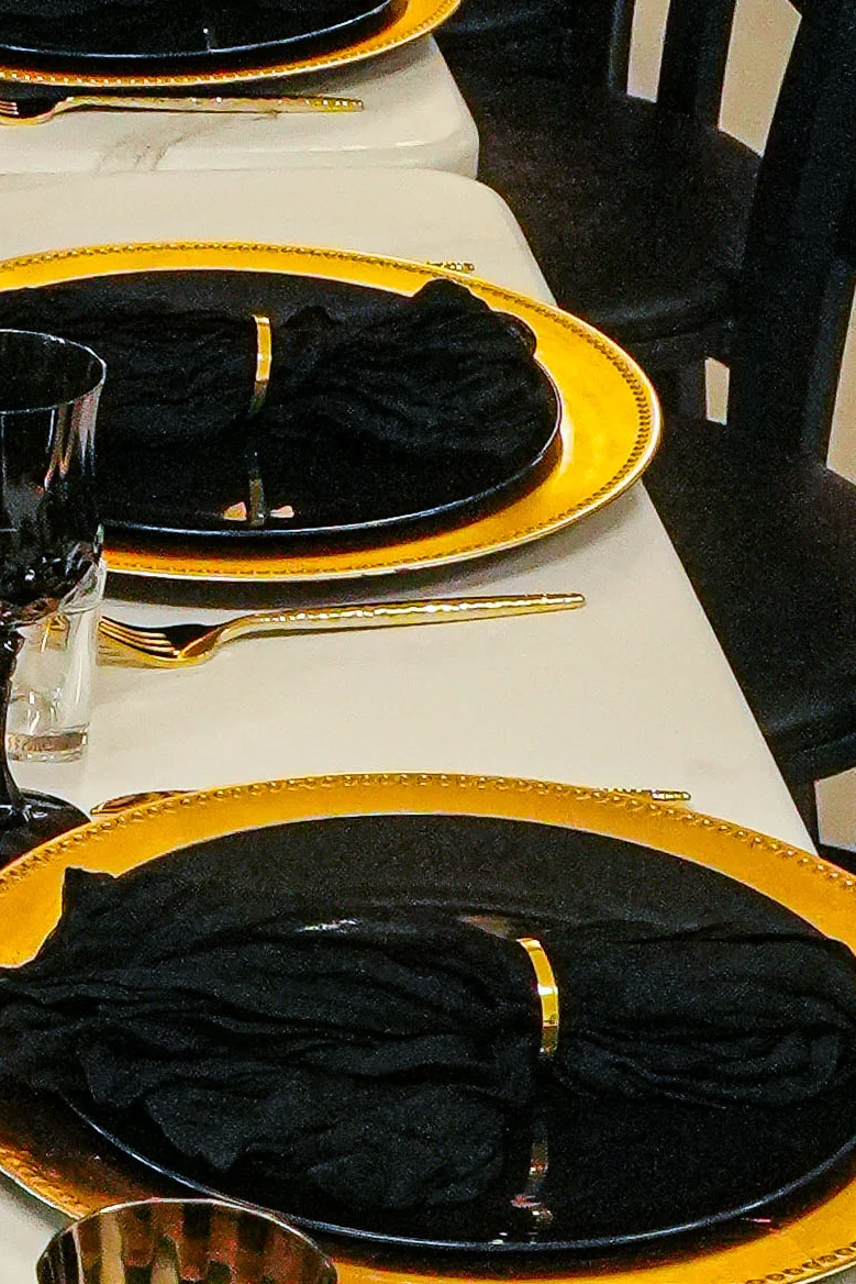 Elegant dining setup with black and gold decor and red roses